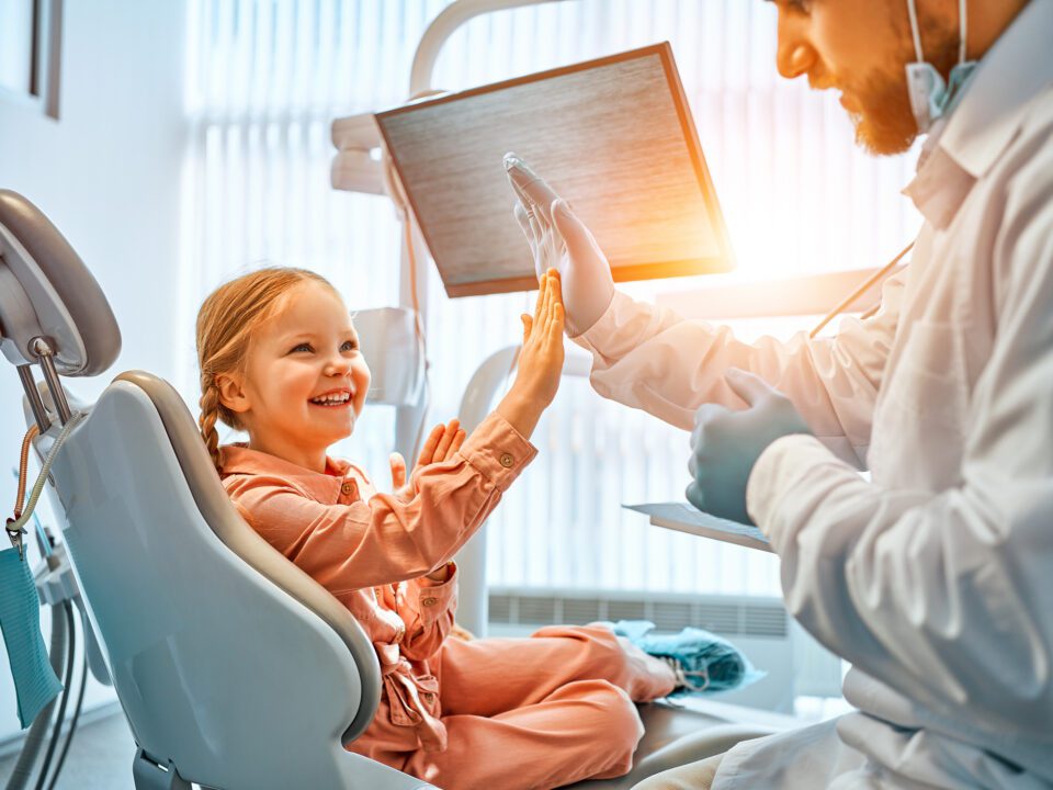 Pediatric dental patient smiling with the dentist