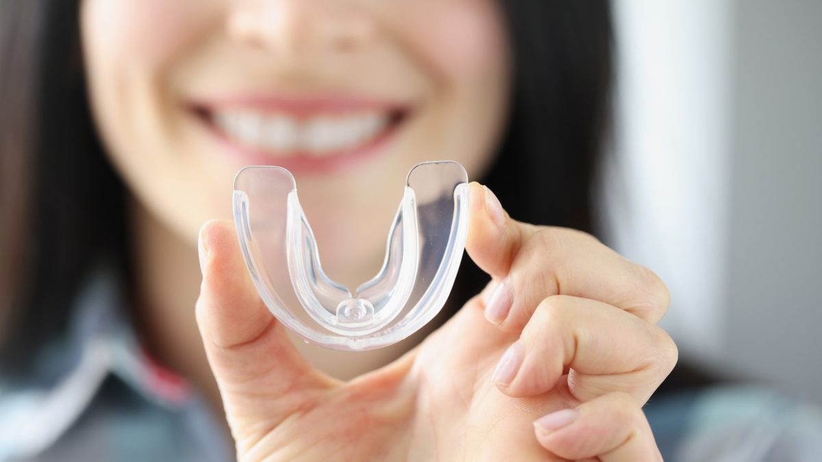 Dental patient holding a mouthguard