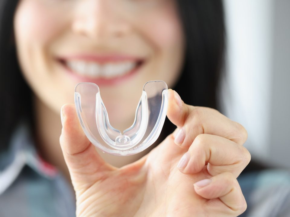 Dental patient holding a mouthguard