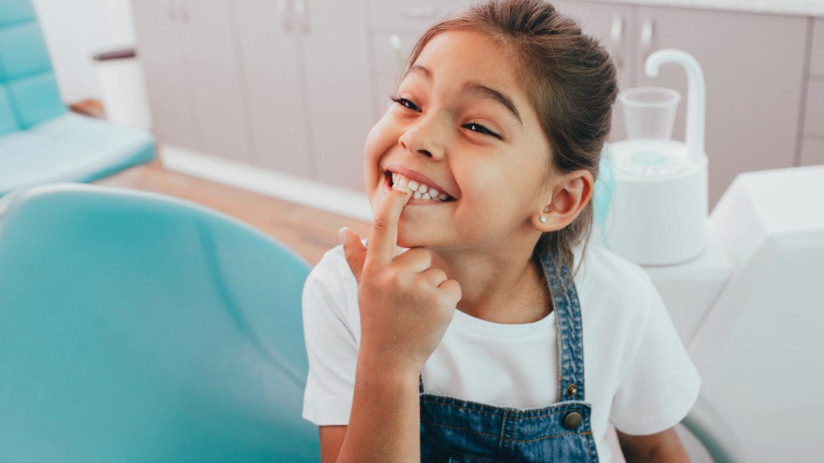 Pediatric dental patient smiling showing their teeth